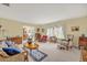 Comfortable living room with carpet, vintage furniture, and dining area in the background at 1115 Lake Francis Dr, Apopka, FL 32712