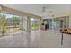 Sunroom featuring tile floors, ceiling fan, glass walls, and sliding doors for ample natural light at 1115 Lake Francis Dr, Apopka, FL 32712