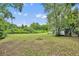 Large backyard with an in-ground fire pit and natural surroundings, a perfect setting for outdoor relaxation and gatherings at 1161 Dot Dr, Altamonte Springs, FL 32714