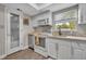 Well-lit kitchen with white cabinets, stainless steel appliances, and a door leading to another room at 1161 Dot Dr, Altamonte Springs, FL 32714