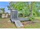 This backyard features a modern shed on a dark wood deck with a ramp and a new-looking door at 1161 Dot Dr, Altamonte Springs, FL 32714