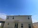 Two-story home featuring neutral siding, ample windows, and sliding glass door under a sunny, blue sky at 1193 Catskill Dr, Haines City, FL 33844