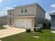 Two-story home showcasing an attached garage and a neatly maintained front lawn at 1193 Catskill Dr, Haines City, FL 33844