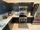 Modern kitchen features stainless steel appliances, granite countertops, and sleek dark cabinetry at 1193 Catskill Dr, Haines City, FL 33844