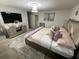 This main bedroom features a comfortable bed, television, unique lighting, and neutral colors at 1193 Catskill Dr, Haines City, FL 33844