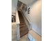 Carpeted staircase with white railing and decorative wall art, leading to the upper level of the home at 1193 Catskill Dr, Haines City, FL 33844