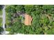 Aerial view of a home with a brown roof nestled among mature trees, providing a sense of privacy at 127 Oak Ln, Ormond Beach, FL 32174