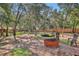 Spacious backyard with mature trees, a fire pit, and seating areas at 127 Oak Ln, Ormond Beach, FL 32174