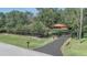 Distant view of a private, single-story home with a driveway, American Flag and a lush lawn at 127 Oak Ln, Ormond Beach, FL 32174