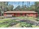 Charming single-story home with an inviting front porch, lush landscaping, and an attached garage at 127 Oak Ln, Ormond Beach, FL 32174
