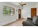 Bright living room featuring wood floors, a large window, and a comfortable leather couch at 127 Oak Ln, Ormond Beach, FL 32174