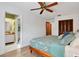 Spacious main bedroom shows a glimpse of a bathroom, with a ceiling fan, wood floors, and a large bed at 127 Oak Ln, Ormond Beach, FL 32174