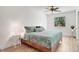 Bright main bedroom featuring a large bed with stylish bedding, wood floors, a ceiling fan, and a large window at 127 Oak Ln, Ormond Beach, FL 32174