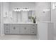 Beautiful bathroom featuring a double sink vanity, white countertops, grey cabinets, and a glass-enclosed shower at 13194 Magnolia Valley Dr, Clermont, FL 34711