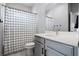 Clean, bright bathroom with square-patterned shower curtain and sleek vanity at 13194 Magnolia Valley Dr, Clermont, FL 34711