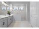 Bright bathroom featuring a double sink vanity, white countertops, grey cabinets, and a walk-in shower at 13194 Magnolia Valley Dr, Clermont, FL 34711