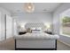A bright bedroom featuring a tufted headboard bed, soft carpet, and a decorative chandelier light fixture at 13194 Magnolia Valley Dr, Clermont, FL 34711