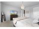 Cozy bedroom features neutral walls, soft carpet, decorative chandelier, and is furnished with a dresser and a large television at 13194 Magnolia Valley Dr, Clermont, FL 34711