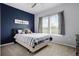 Stylish bedroom with a navy accent wall, plush carpets, and a bright window at 13194 Magnolia Valley Dr, Clermont, FL 34711