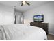 Cozy bedroom featuring a plush chair, dresser with TV, and bright lighting at 13194 Magnolia Valley Dr, Clermont, FL 34711