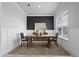 Elegant dining room with modern decor, featuring a black accent wall, wood table, and stylish rug at 13194 Magnolia Valley Dr, Clermont, FL 34711