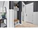 A welcoming entryway boasting a built-in bench with a wooden seat, white wainscoting, and stylish wall decor at 13194 Magnolia Valley Dr, Clermont, FL 34711
