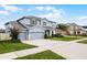 Charming two-story home with a three-car garage, well-maintained lawn, and manicured landscaping at 13194 Magnolia Valley Dr, Clermont, FL 34711