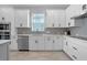 Modern kitchen with white cabinets, stainless steel appliances, and a stylish tile backsplash at 13194 Magnolia Valley Dr, Clermont, FL 34711