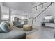 Spacious living room with a grey sectional sofa, open floor plan, and a staircase with white railings at 13194 Magnolia Valley Dr, Clermont, FL 34711