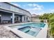 Inviting backyard pool and spa with a basketball hoop, surrounded by a paved patio and lush landscaping at 13194 Magnolia Valley Dr, Clermont, FL 34711