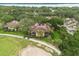 Aerial view showcasing lush landscaping, the community's golf course frontage, and the property's tile roof at 14 Camino Real Blvd # 14, Howey In The Hills, FL 34737