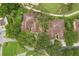 An aerial view capturing the community's tile roofs, lush lawns, tree coverage, and winding roads throughout the property at 14 Camino Real Blvd # 14, Howey In The Hills, FL 34737