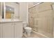 Bathroom featuring a tile shower with sliding glass door, toilet, and white vanity with sink and framed mirror at 14 Camino Real Blvd # 14, Howey In The Hills, FL 34737