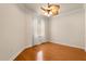 This bedroom features hardwood floors, a light-colored ceiling fan, one window with blinds and bright neutral colored walls at 14 Camino Real Blvd # 14, Howey In The Hills, FL 34737