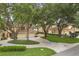 A view of the home exteriors showing lush lawns, mature trees, beautiful landscaping, and paver driveways at 14 Camino Real Blvd # 14, Howey In The Hills, FL 34737