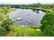 Stunning aerial view of a lakefront property with a private dock, boats, and lush green surroundings at 1405 Periwinkle Ave, Deland, FL 32724