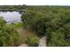 Aerial view of the property showcasing a lakefront location with a private driveway and lush landscaping at 1405 Periwinkle Ave, Deland, FL 32724