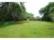 Large, lush backyard featuring a canoe and view of the home with a covered patio, ideal for outdoor living at 1405 Periwinkle Ave, Deland, FL 32724