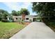 Charming home with a well-maintained lawn, mature trees, and a long driveway leading to a carport at 1405 Periwinkle Ave, Deland, FL 32724