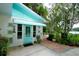 Single-story home with turquoise accents, surrounded by tropical plants and lush greenery at 1405 Periwinkle Ave, Deland, FL 32724