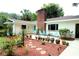 Charming single-story house with a brick chimney, turquoise accents, and a lush, landscaped front yard at 1405 Periwinkle Ave, Deland, FL 32724