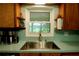 View of the stainless steel kitchen sink and window with view of the backyard at 1405 Periwinkle Ave, Deland, FL 32724
