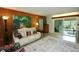 Cozy living room with wood paneling, a painting and sliding glass doors to the backyard at 1405 Periwinkle Ave, Deland, FL 32724