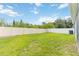 Large backyard with a well-maintained lawn and a white privacy fence at 141 Sandestin Dr, Haines City, FL 33844