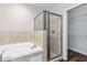 Bright bathroom featuring a garden tub, glass shower and walk-in closet with installed wire shelving at 141 Sandestin Dr, Haines City, FL 33844