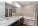 Modern bathroom featuring double sinks, a soaking tub, and a glass-enclosed shower at 141 Sandestin Dr, Haines City, FL 33844