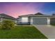 Charming single-Gathering home with a well-maintained lawn and a two-car garage at dusk at 141 Sandestin Dr, Haines City, FL 33844