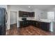 Open kitchen has dark wood cabinets, modern appliances, and a seamless connection to the living area at 141 Sandestin Dr, Haines City, FL 33844