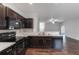 Open kitchen has dark wood cabinets, modern appliances, and a seamless connection to the living area at 141 Sandestin Dr, Haines City, FL 33844