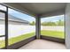 Spacious screened-in patio with views of the green backyard and white fence at 141 Sandestin Dr, Haines City, FL 33844